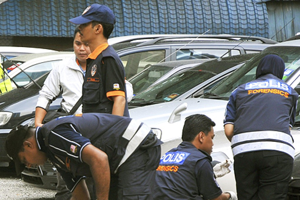 Malaysian forensic police officers investigate the shooting death of Hussain Ahmad Najadik in Kuala Lumpur, Malaysia. Photo: AP
