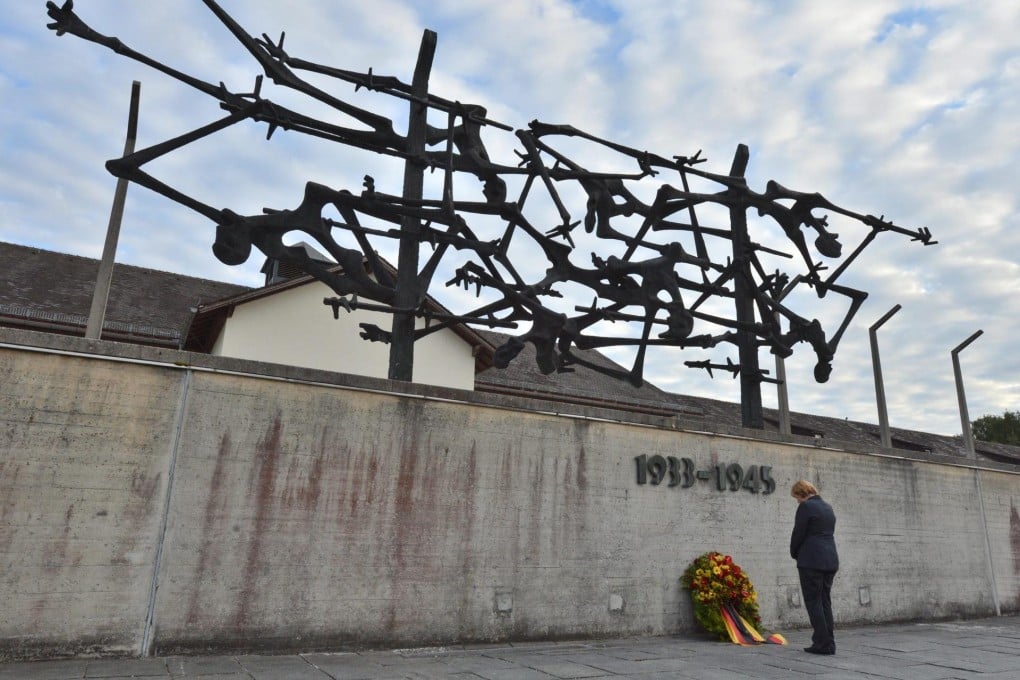 German Chancellor Angela Merkel pays her respects at Dachau. Her visit to the memorial has sparked controversy. Photo: EPA