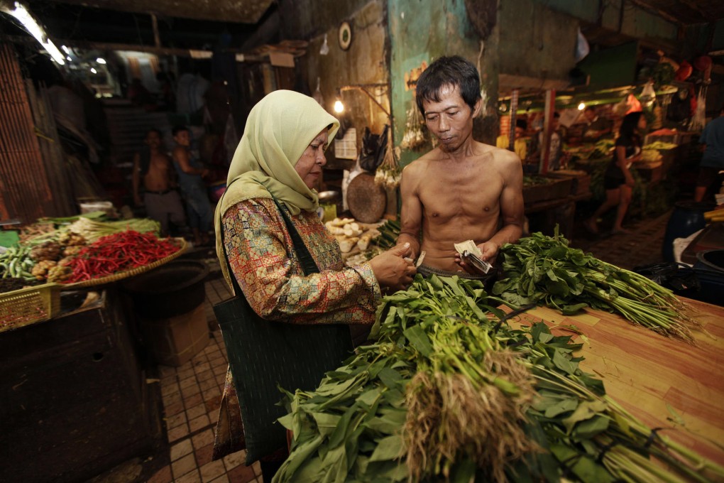 A customer buys vegetables at a market in Jakarta, where fuel-driven inflation is biting into incomes of poor and middle-class Indonesians. Photo: Bloomberg