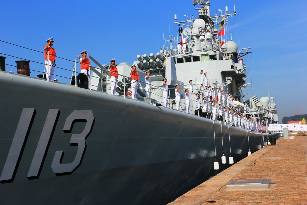 Officers and soldiers of the Chinese navy stand on the missile destroyer Qingdao at a military port in Qingdao. Photo: Xinhua