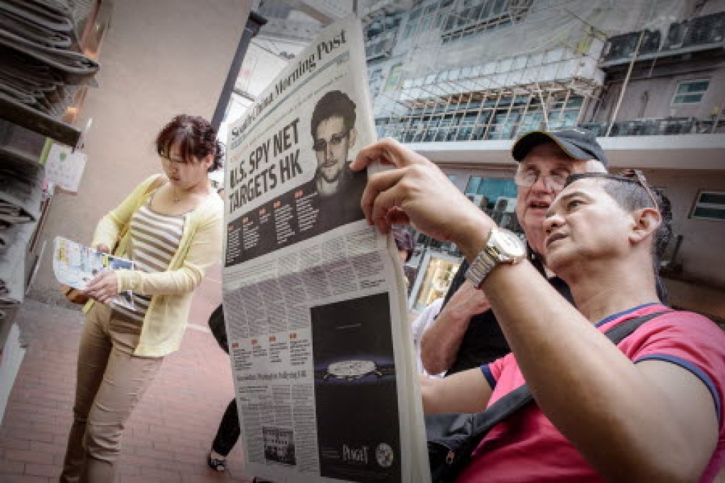 Two men read an edition of the South China Morning Post carrying the story of Edward Snowden on its front page in Hong Kong. Photo: AFP