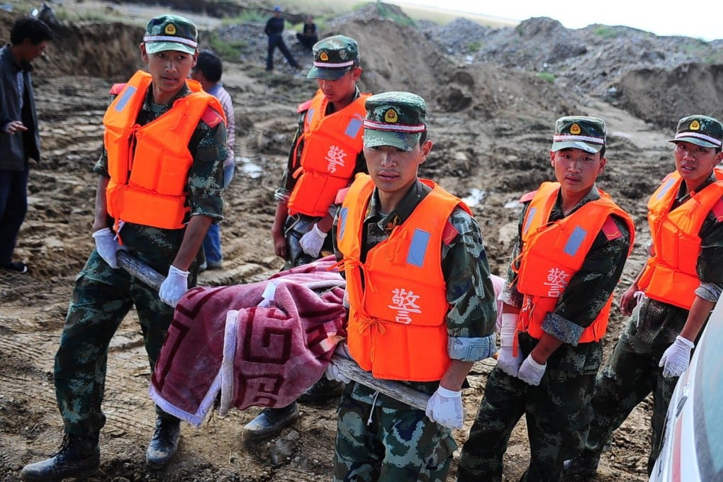 Soldiers carry the body of a flood victim in Wulan county in Haixi, Qinghai. Photo: Xinhua
