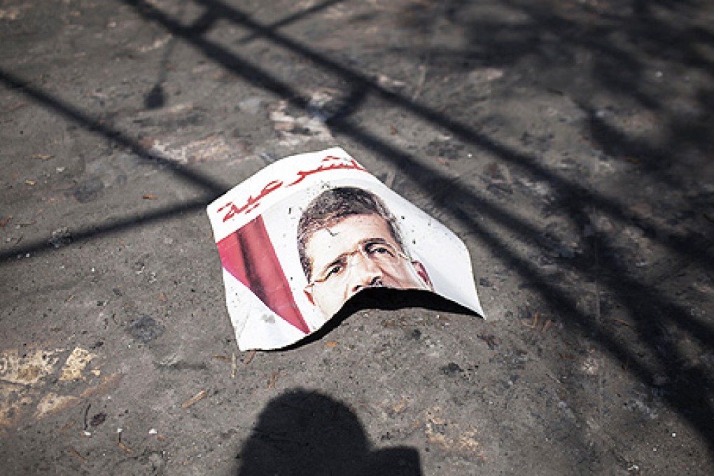 A ripped poster of ousted President Mohammed Mursi lies on the ground in the courtyard of the Rabaah Al-Adawiya mosque in Nasr city, Cairo, as Egypt's new military-backed leaders crack down on Islamists. Photo: AP
