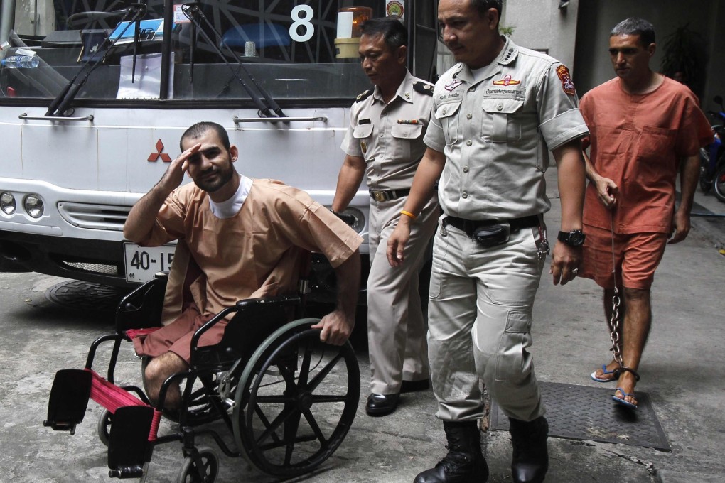 Thai prison officers escort Iranian Saeid Moradi, 29, in wheelchair, and Mohammad Khazaei, 43, as they leave the Bangkok South Criminal Court on Thursday.