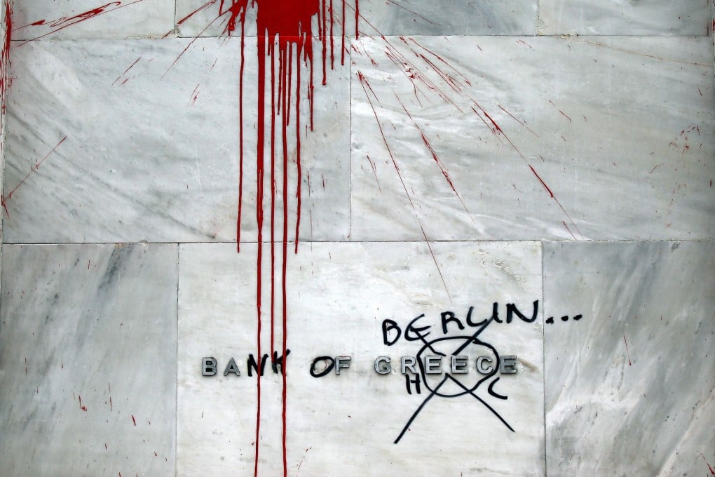 A sign at the central bank of Greece is covered in graffiti that says "Bank of Berlin", reflecting the anger over tough austerity measures. Photo: Bloomberg