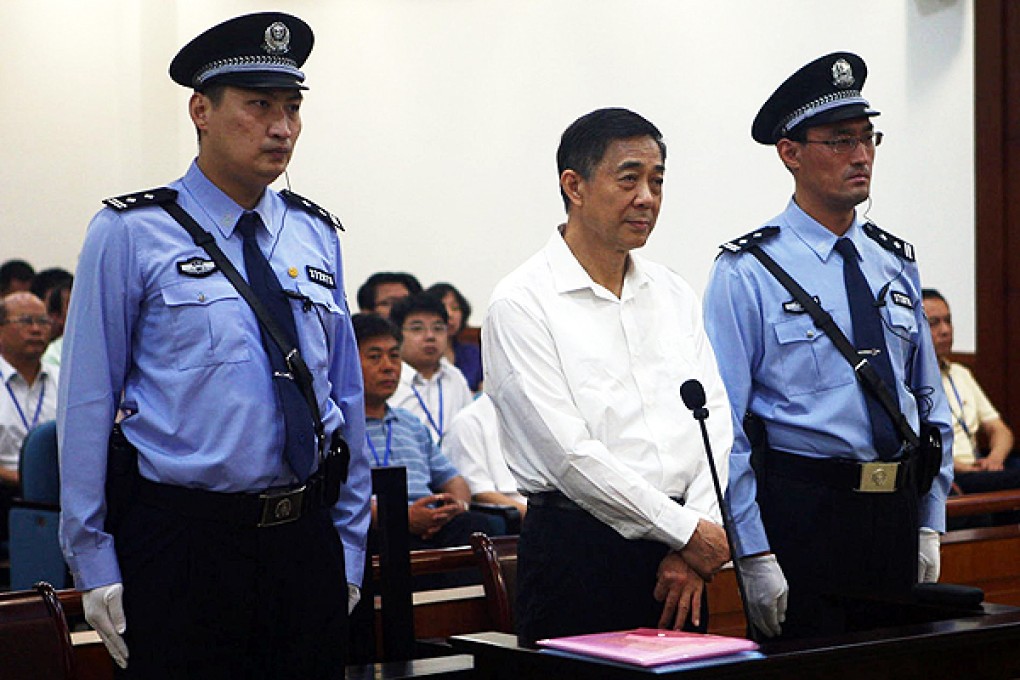 Bo Xilai is flanked by two guards as he is charged at Jinan Intermediate People's Court with the eyes of the world upon him. Photo: Reuters