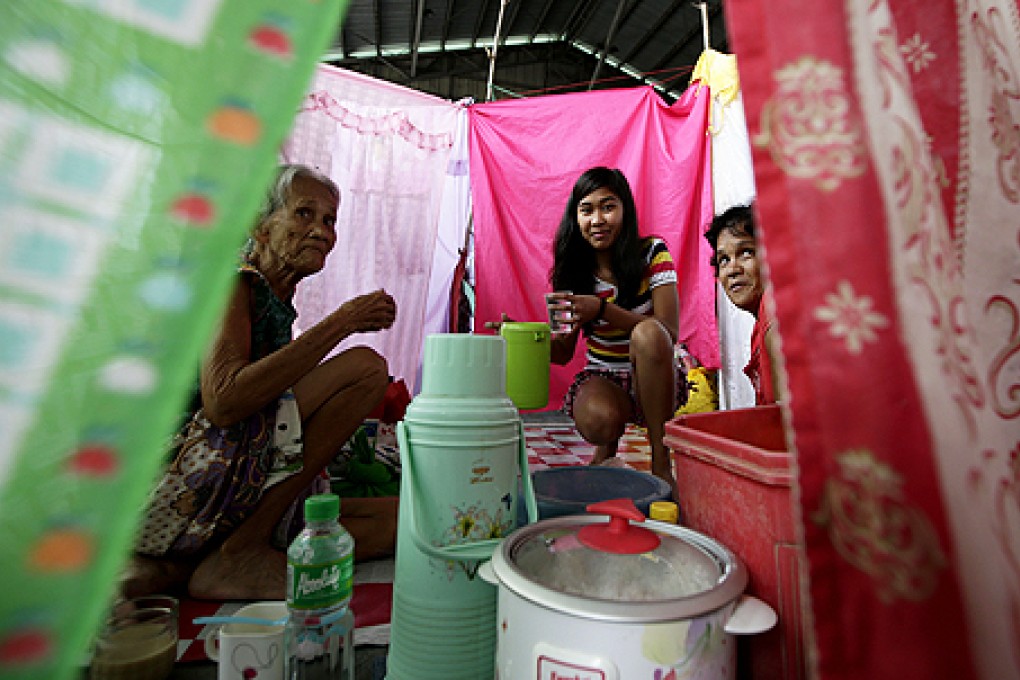 Evacuees take their meals inside a basketball court serving as their temporary shelter following the flooding at Calumpit township, Bulacan province, north of Manila, Philippines, on Thursday. Photo: AP