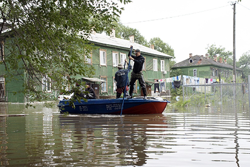 Emergency Ministry employees evacuate people from a flooded village at the Bolshoi Ussuriysky Island on the Amur river in Khabarovsk region. Photo: AP