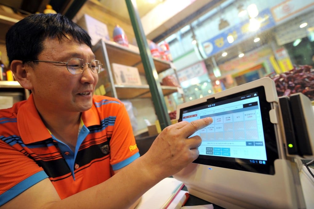 Oil-seller Yoo has switched to a touchscreen tablet. Photo: AFP