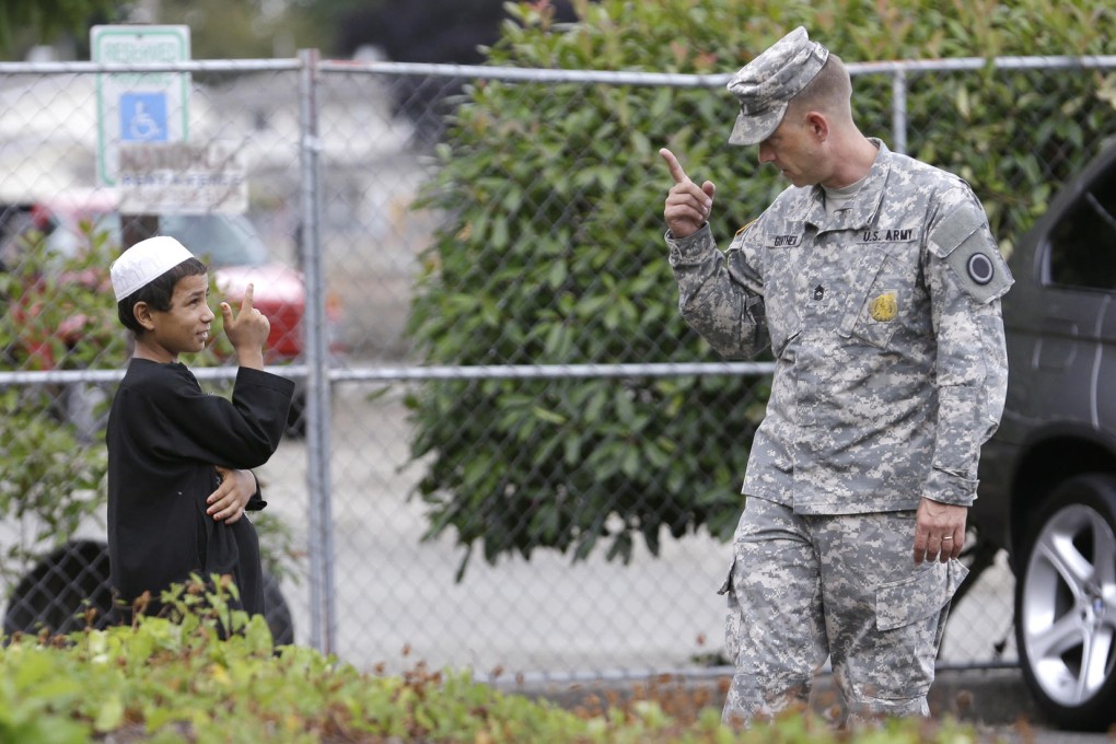 An Afghan boy shares a friendly moment with a US soldier after Robert Bales' sentencing hearing at a military base in Washington. Photo: AP