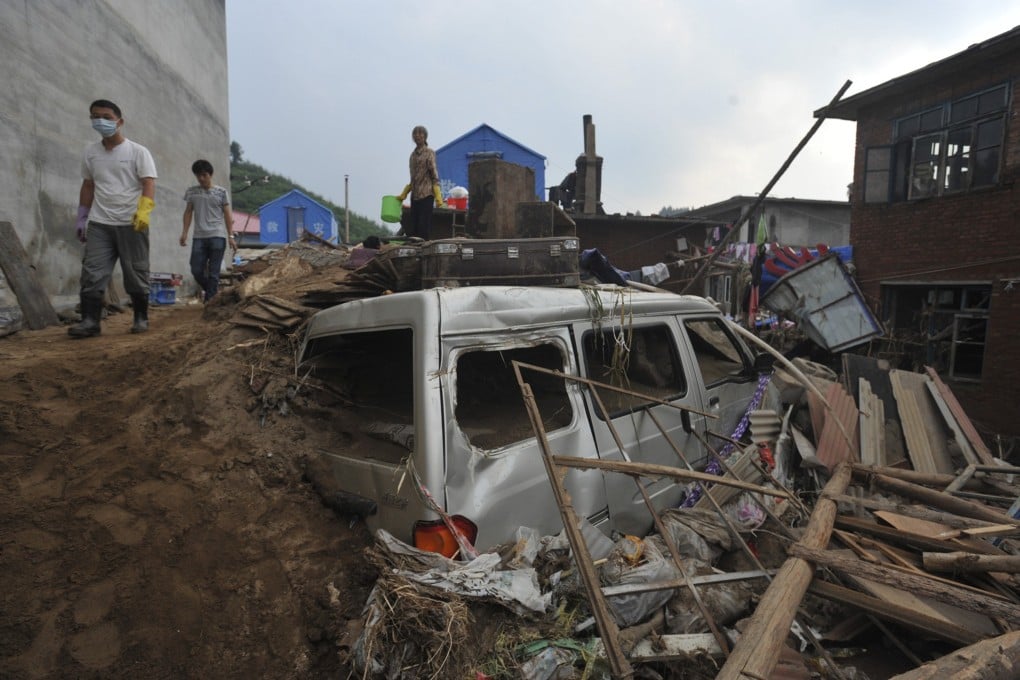 People walk through a flooded area after the floods in Fushun, in northeast China's Liaoning province. The floods have killed 76 people. Photo: AP