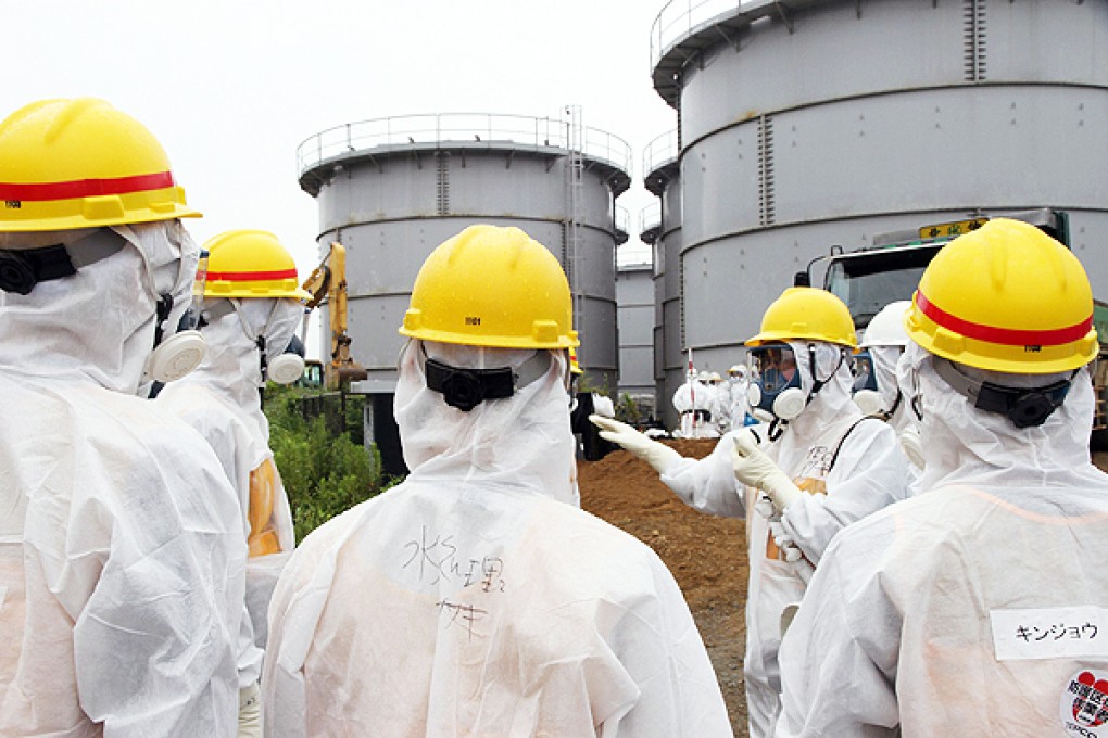 Members of Japan's Nuclear Regulation Authority  inspect contaminated water tanks at the Fukushima nuclear power plant in Okuma. Photo: AFP