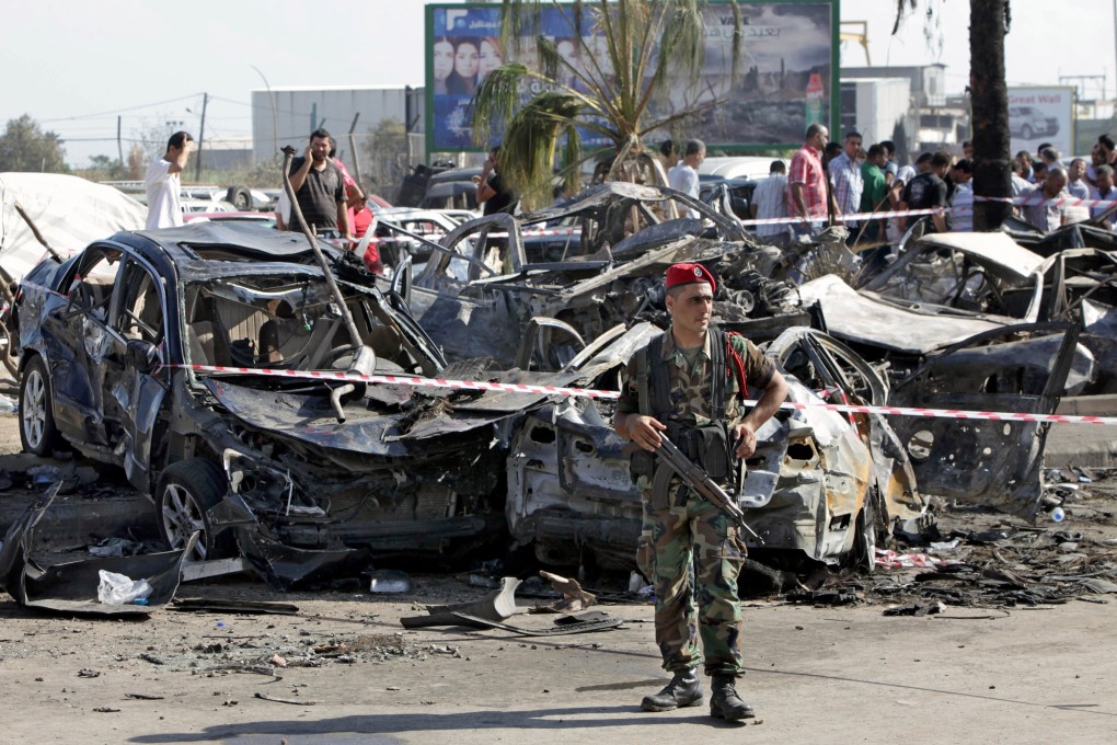 A Lebanese Army soldier stands guard in front of damaged cars at the site of a car bomb explosion outside of the Al-Taqwa mosque, in the northern city of Tripoli, Lebanon, on Saturday. Photo: AFP