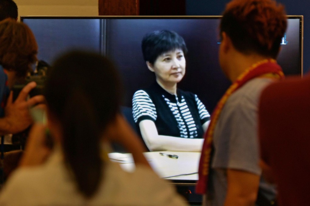 Journalists watch Gu Kailai's recorded testimony shown during Bo Xilai's trial. Photo: AFP