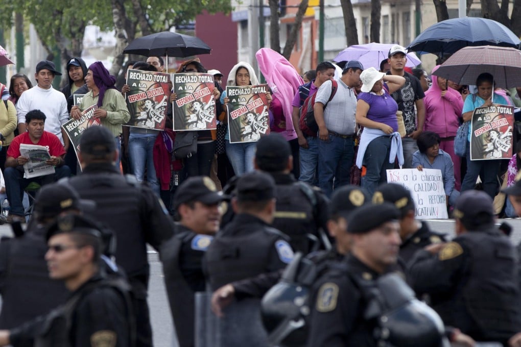 Teachers rally in front of riot police in Mexico City. Photo: AP
