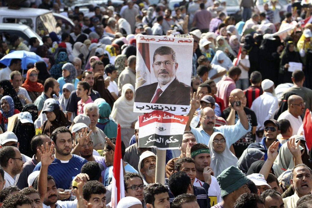 Supporters of Muslim Brotherhood and ousted Egyptian President Mursi display a poster of Mursi during a protest in Cairo. Photo: Reuters