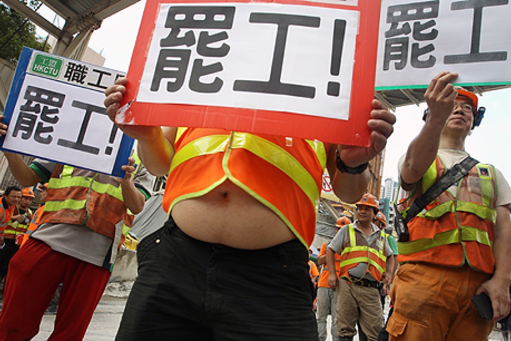 Workers  with their "On strike!" signs press for changes to regulations imposed on them by their employer on Monday. Photo: Sam Tsang