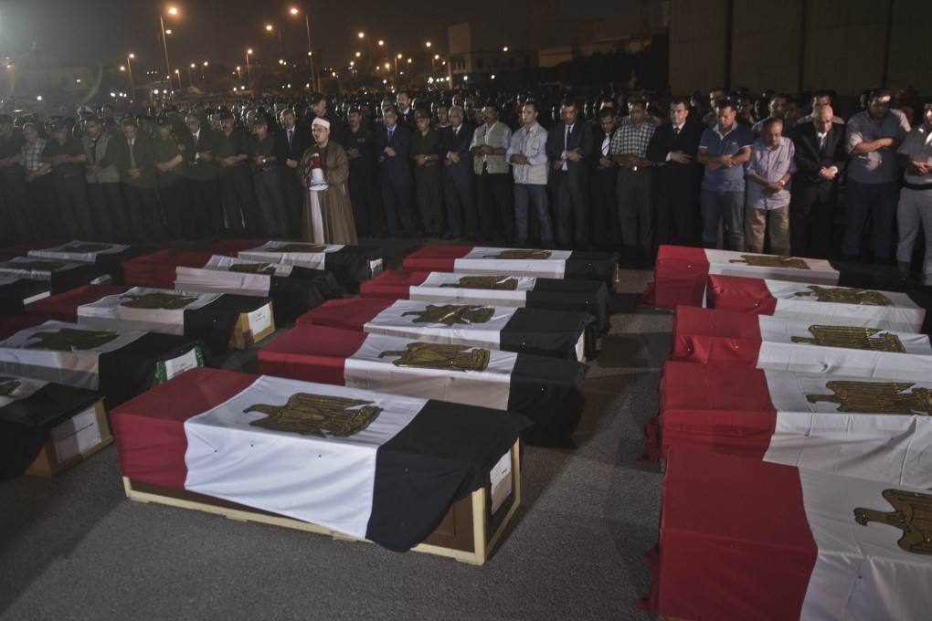 Egyptian army and security officers pray over coffins covered with the national flags at Almaza military Airbase in Cairo. There is also growing concern in Egypt about deaths occurring in police custody. Photo: AFP
