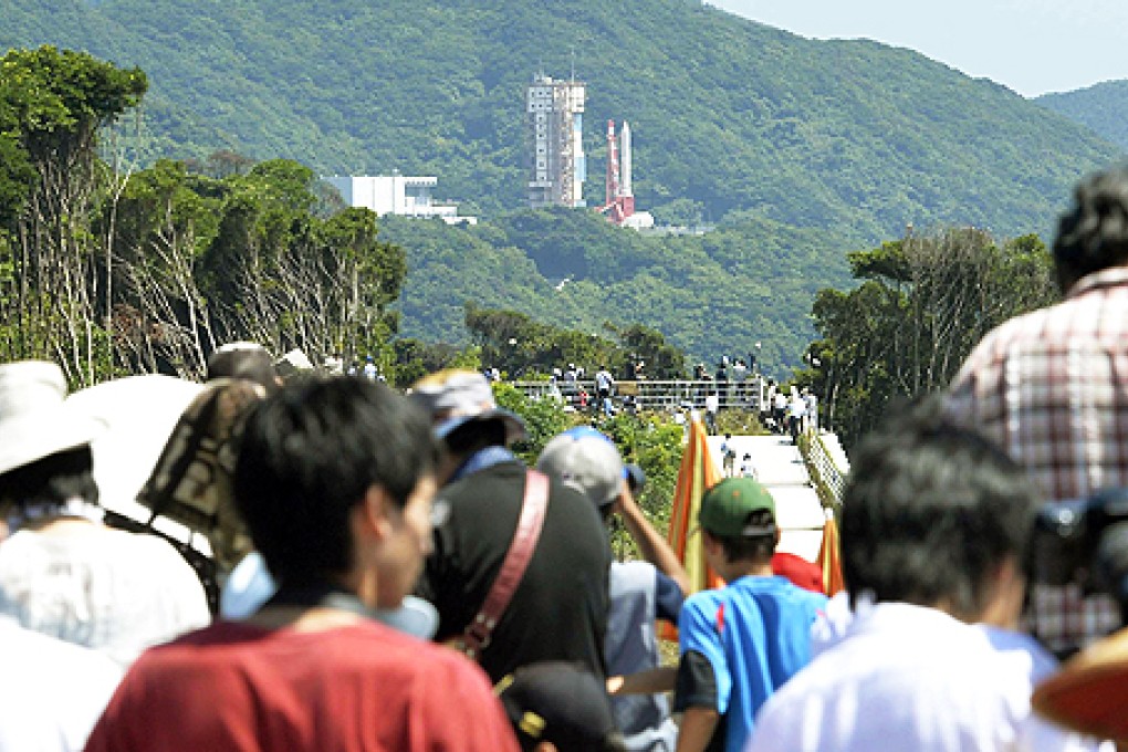 Spectators gather to watch an Epsilon rocket, seen in the background, before its launch at the Uchinoura Space Centre in Kimotsuki town, Kagoshima, western Japan on Tuesday. Photo: AP