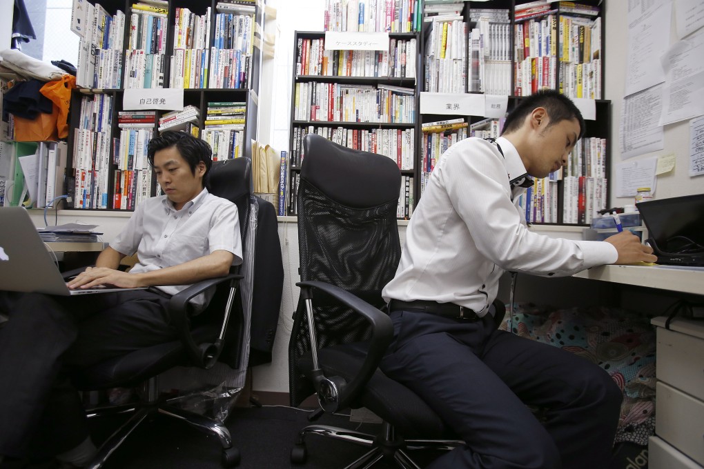 Koshi Kuwahara (right) and Shimpei Kato work at Terra Motors, which already leads Japan’s electric scooter market and is looking overseas. Photo: AP