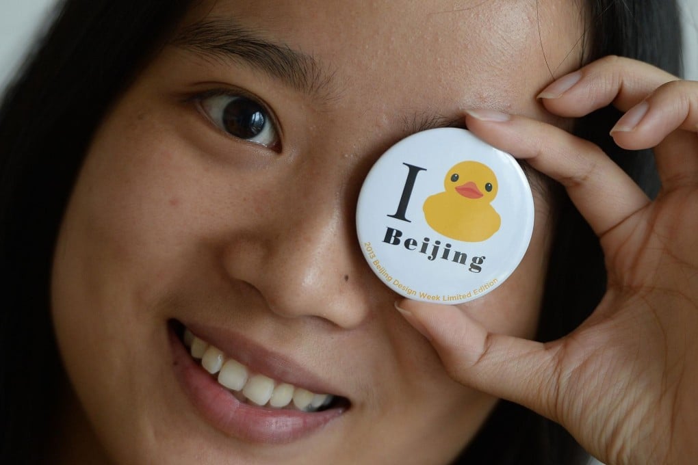 A young woman poses at a press conference in Beijing to announce the visit by artist Florentijn Hofman's rubber duck. Photo: AFP