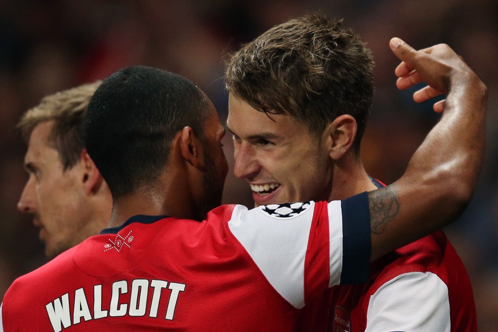 Arsenal's English midfielder Theo Walcott (left) celebrates with Arsenal's Welsh midfielder Aaron Ramsey (right) during the Uefa Champions League Play-Off football match in north London on Tuesday. Photo: AFP