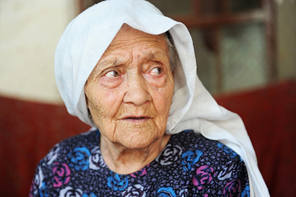 Alimihan Seyiti sits in her home in Shule county of Kashgar, northwest China's Xinjiang region. A Chinese government news portal has claimed that Seyiti is 127 years old but experts have raised questions over the supposed record. Photo: AFP