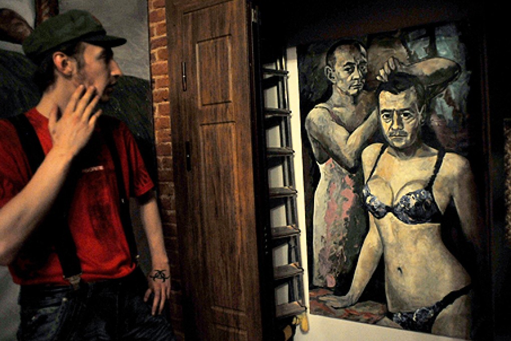 A visitor looks at an artwork by Russian artist Konstantin Altunin representing Russia's President Vladimir Putin and Prime Minister Dmitry Medvedev in women's lingerie during the 'Leaders' exhibition in the central St Petersburg. Photo: AFP