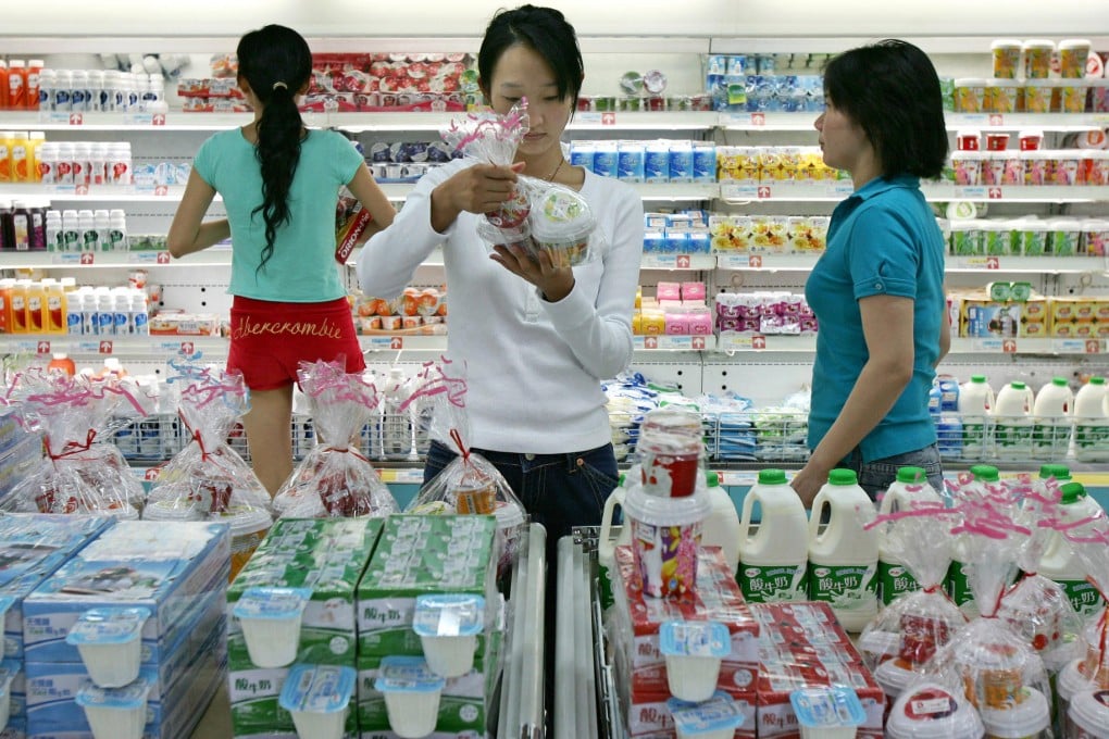 A Beijing shopper examines milk from China Mengniu Dairy, the main client for China Modern Dairy's raw milk. Photo: Bloomberg