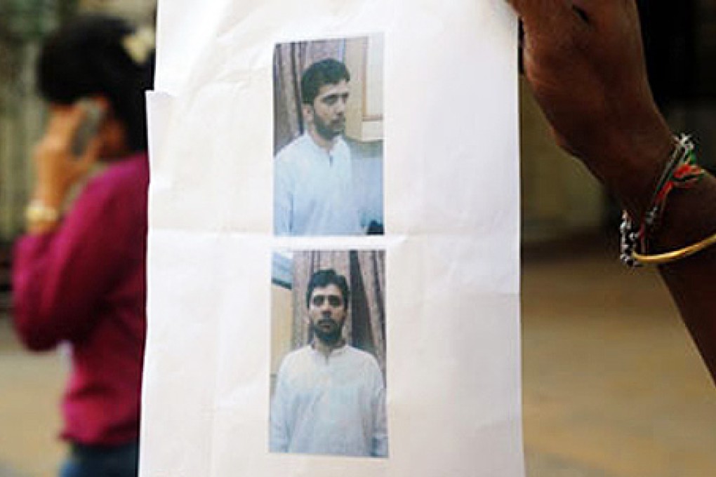 A man shows a police hand-out with pictures of Yasin Bhatkal, the alleged commander of Indian Mujahideen. Photo: AFP