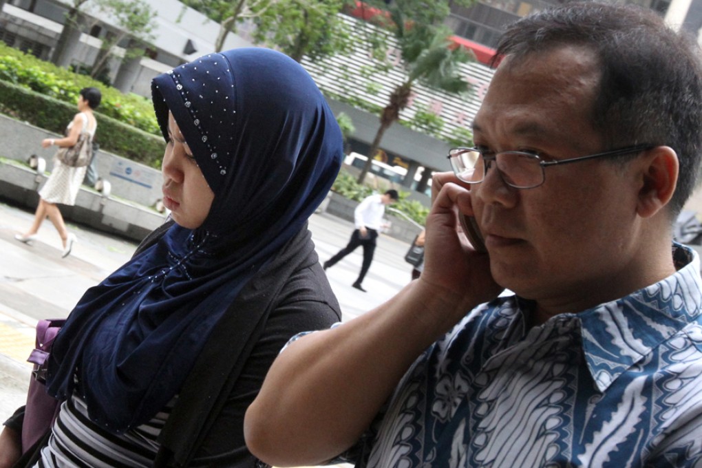 Kartika Puspitasari, whose employers allegedly beat her and burned her with an iron, with a supporter outside court. Photo: David Wong