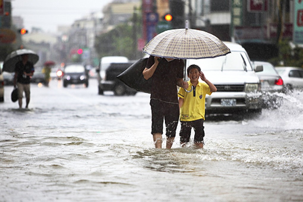 Local residents walk through floodwaters from passing Tropical Storm Kong-Rey in Tainan, Taiwan, on Thursday. Photo: AP