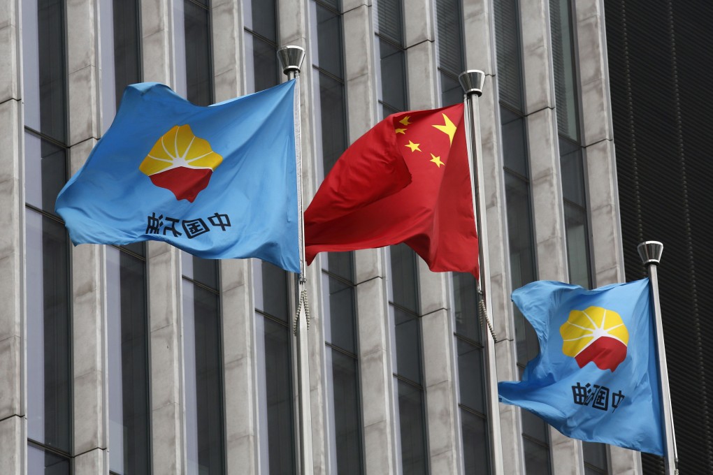 A Chinese national flag flutters between PetroChina's flags at headquarters in Beijing. Photo: Reuters