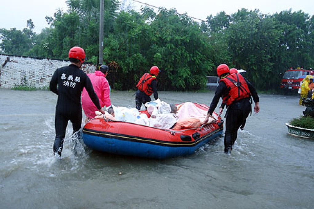 Rescuers use a rubber boat to transfer a man to safety in flooded south-east Taiwan. Photo: Xinhua