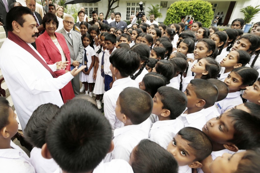UN human rights chief Navi Pillay (2nd left) looks on as Sri Lankan President Mahinda Rajapakse (left) gestures which meeting visiting schoolchildren at his official residence in Colombo. Photo: AFP