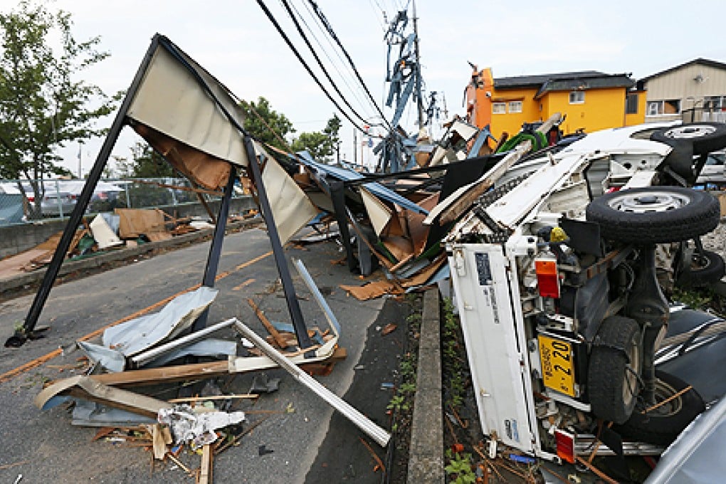 An upturned vehicle and debris are left after a tornado hit in Koshigaya, Saitama Prefecture, north of Tokyo, Japan, on Monday. Photo: EPA