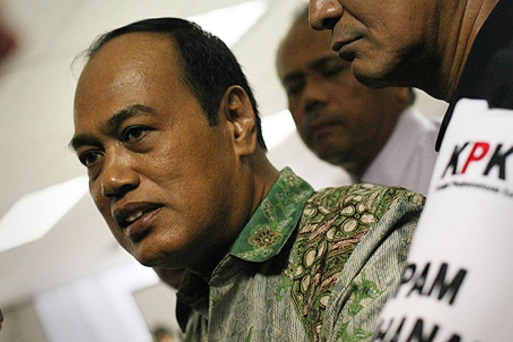 Djoko Susilo (left) is escorted by a guard from the Corruption Eradication Commission after Indonesia's anti-corruption court in Jakarta jailed him for 10 years on Tuesday. Photo: AFP