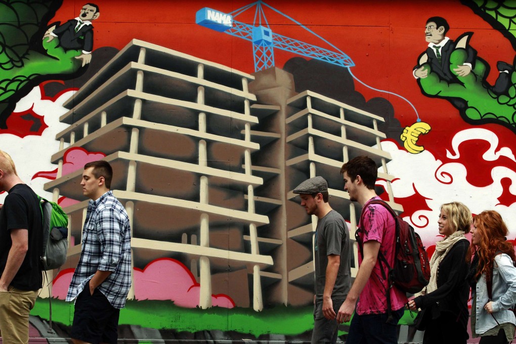 Residential property prices in prime Dublin locations jumped 8 per cent in the 12 months to July as people walk past graffiti in Central Dublin. Photo: Reuters