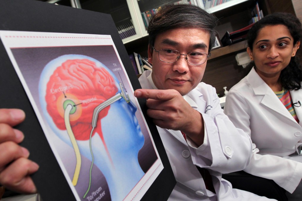 Eye specialist Dr Dennis Lam Shun-chiu and his team will help to restore, free of charge, some sight to a six-year-old boy whose eyes were gouged out by abductors in Shanxi on August 24. Lam is seen here with team member Fairooz Manjandavida explaining the procedure which will include giving the boy electronic eyes. Photo: Nora Tam