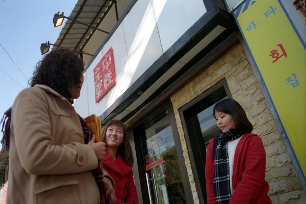 Three Peking University students talk in the capital's Wudaokou district, or "Korea Street". Photo: KRT