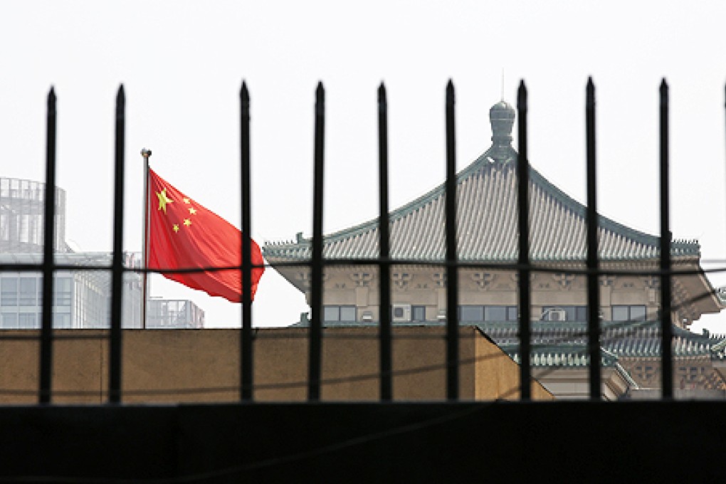 The national flag of China flutters behind a fence of the headquarters of the National Development and Reform Commission, which put pressure on some 30 foreign firms at a meeting in late July to confess to any antitrust violations. Photo: Reuters