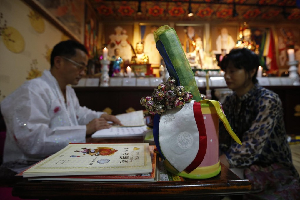 Shaman Choi Kuing-hun foresees a child's future at his house in Seongnam, South Korea. Photo: Reuters