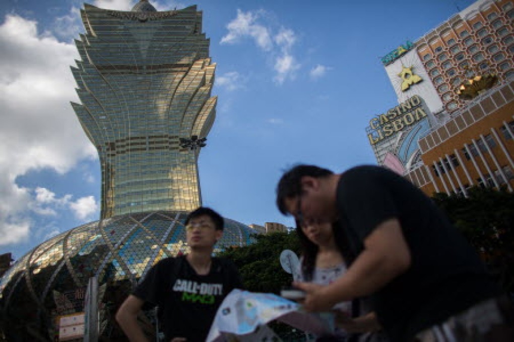 Tourists read the map in front of the Casino Grand Lisboa, operated by SJM Holdings Ltd.in Macau. Photo: Bloomberg