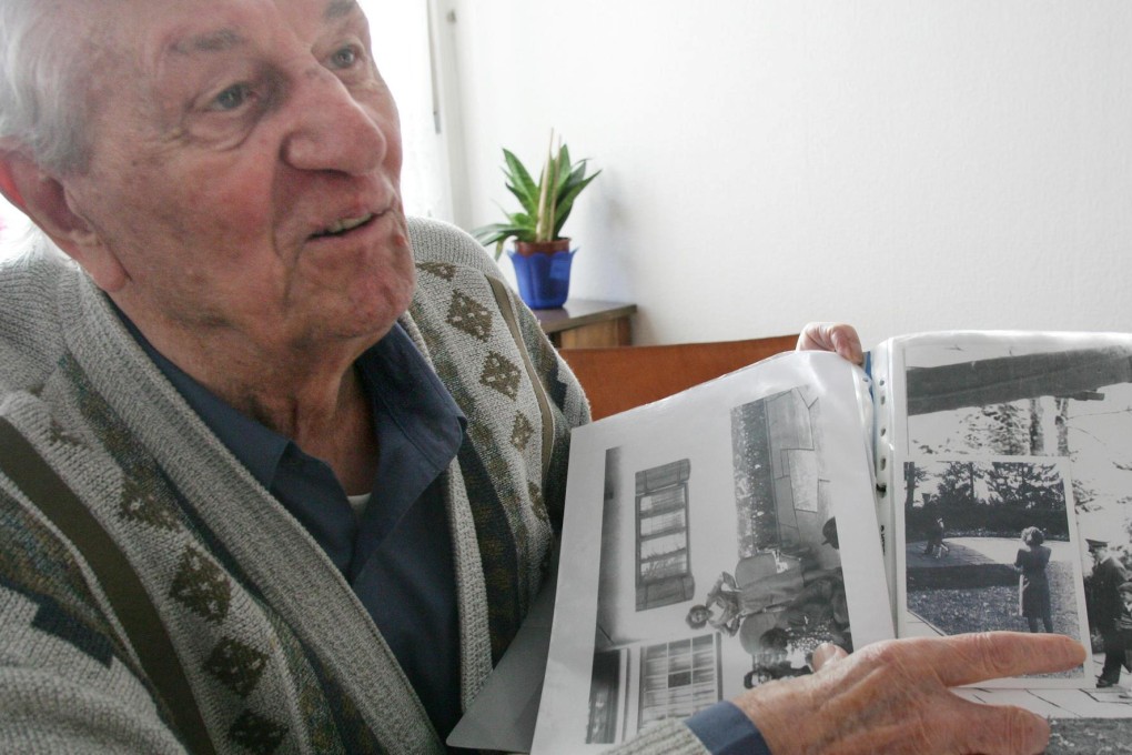Rochus Misch in 2005 with a personal photograph of Adolf Hitler, who he lived with for years. Photo: AP
