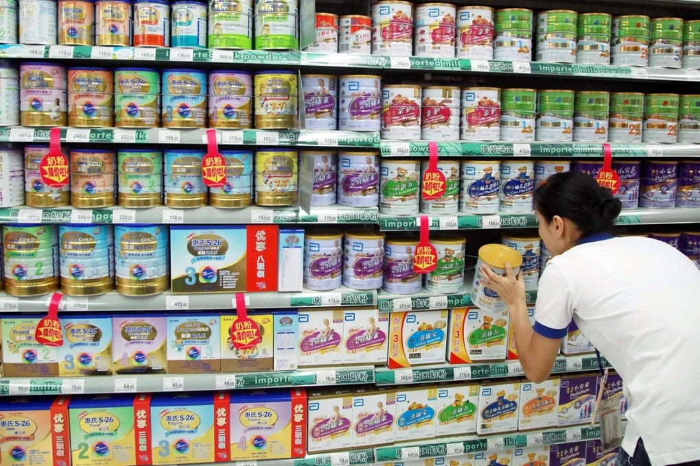 A customer selects baby formula in Haikou, Hainan province as foreign suppliers were fined for price-fixing. Photo: AFP