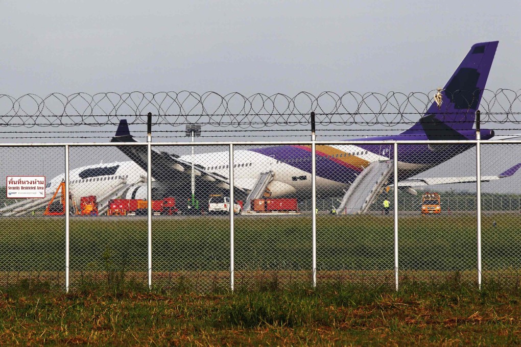 Airport staff work around a Thai Airways plane that skidded off the runaway while landing at Bangkok's Suvarnabhumi Airport. Photo: Reuters