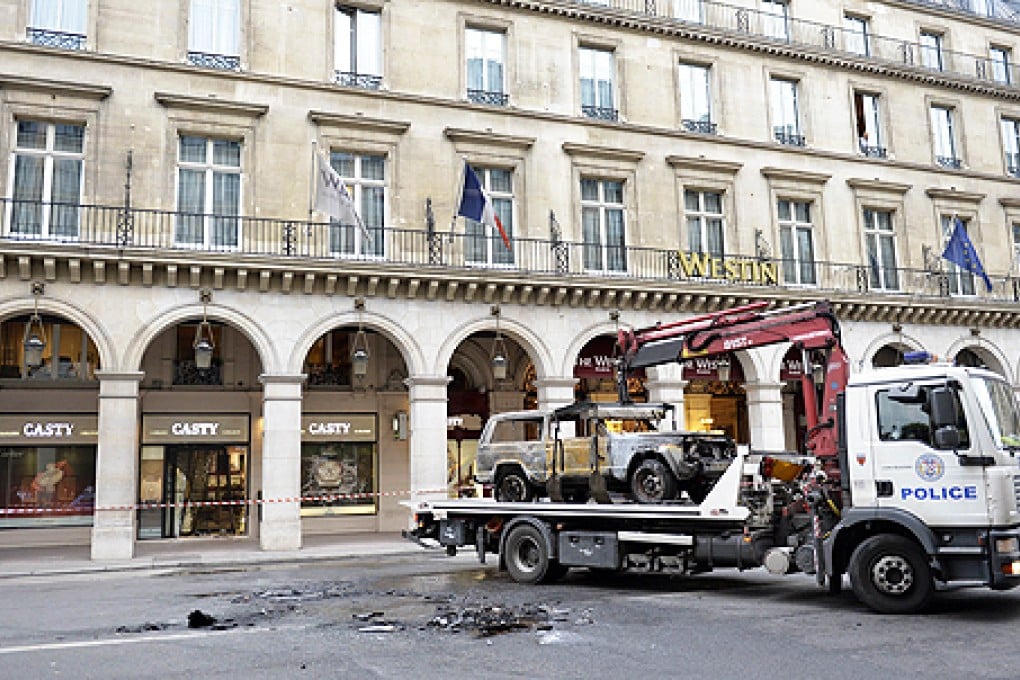 A French police lorry collects a burnt vehicle used to ram-raid a jewelry store in the centre of Paris, on Monday. Photo: AFP