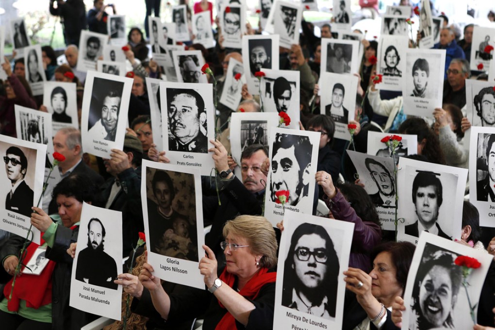 Chileans hold up pictures of victims of human rights abuse during a ceremony commemorating 40 years of the military coup at the Parque Por La Paz in Santiago. Photo: Reuters