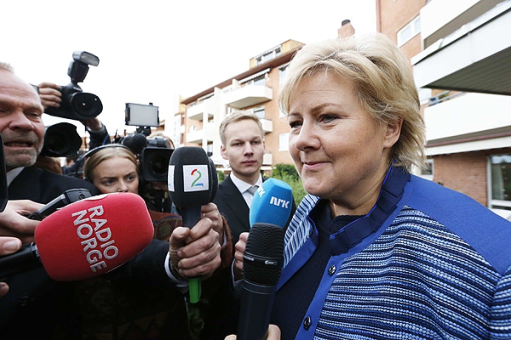 Erna Solberg speaks with the media outside the block of flats where she lives in Oslo. Photo: Reuters