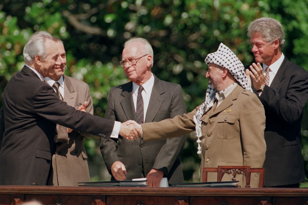 Israeli Foreign Minister Shimon Peres, left, shakes hands with Palestinian Liberation Organization Chairman YasserArafat accompanied by Israeli Prime Minister Yitzhak Rabin (centre) US President Bill Clinton on September 13, 1993. Photo: AFP